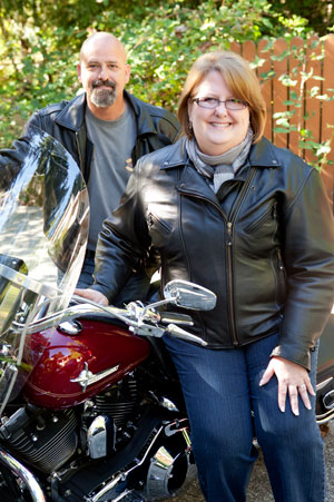 barbara leaning against her motorcycle with her husband